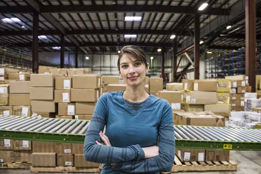 A caucasian female warehouse worker in a distribution warehouse.