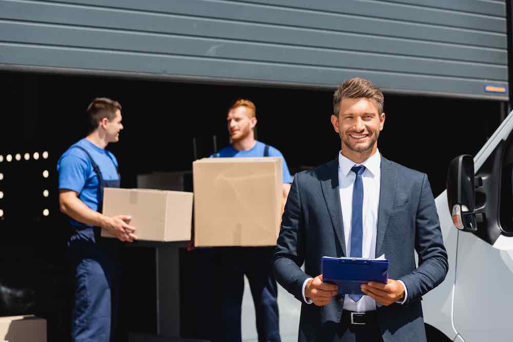 Businessman pleased with movers leveraging AI technology.
