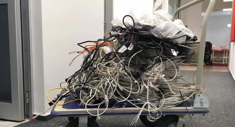 Cart with piles of used internet wires from cable removal service.
